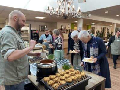 Twee dames staan bij het lunchbuffet een keuze te maken.