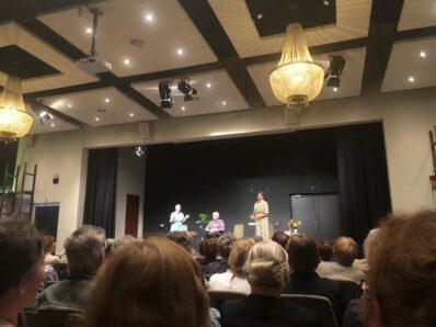Vrijwilligers van Norschoten kijken naar de voorstelling 'Het verpleeghuis is het ‘einde’' van Theater Aan De Lijn