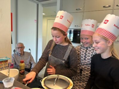 Groep 8a van de Rehobothschool bakken pannenkoeken met een bewoner van locatie Kootwijkerbroek